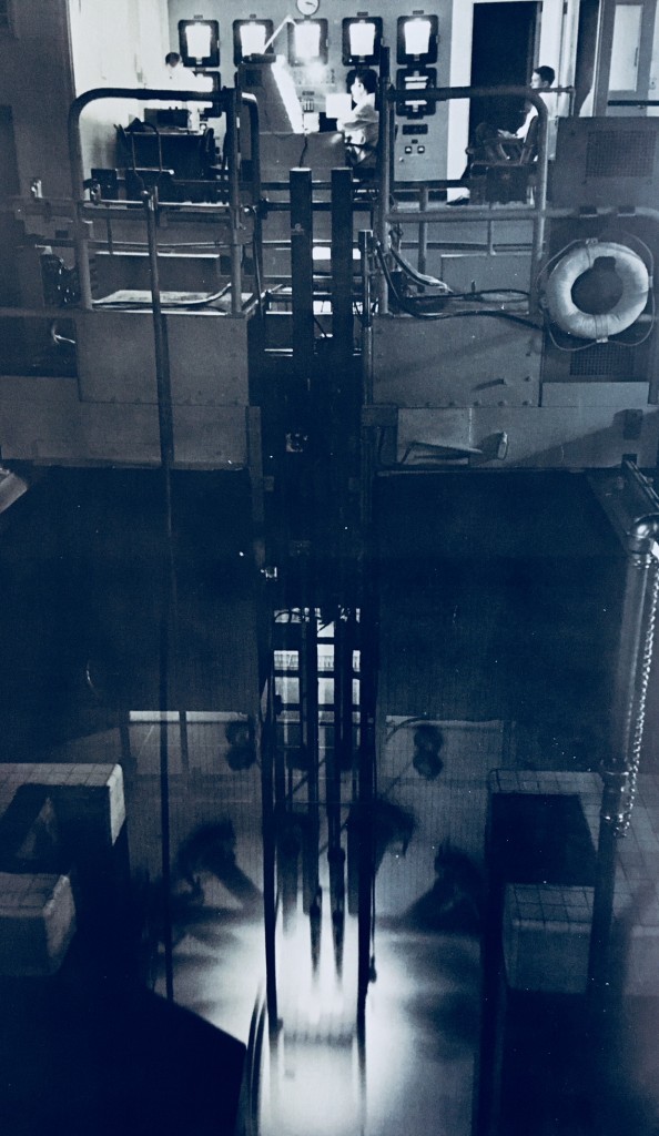 Glorious view of the Ford Nuclear Reactor in operation, from the control room all the way down to the core surrounded by the Cherenkov radiation glow.  Photo from Atoms for Peace / USA 1958, US Atomic Energy Commission.